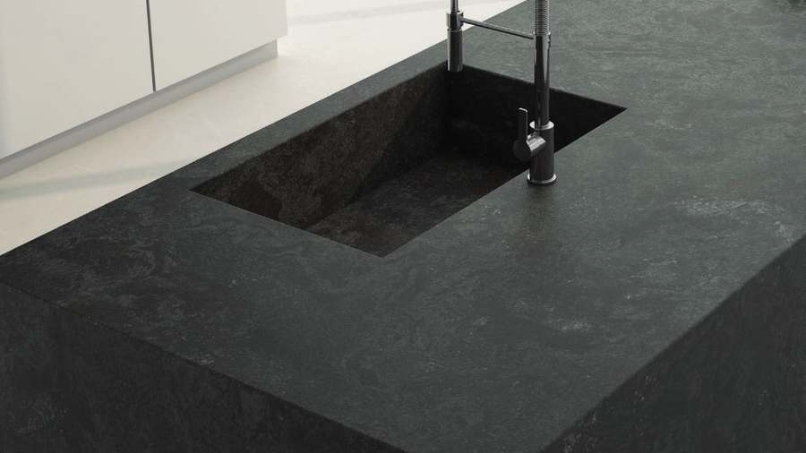 Isla de cocina de porcelánico gris oscuro con aspecto de piedra y fregadero del mismo material