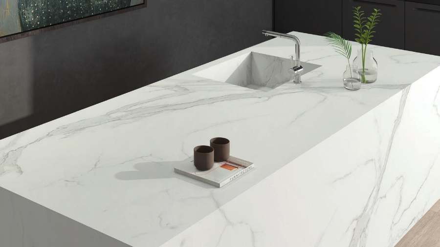Isla de cocina con encimera de porcelánico Estatuario, blanco con vetas grises, vista desde una esquina