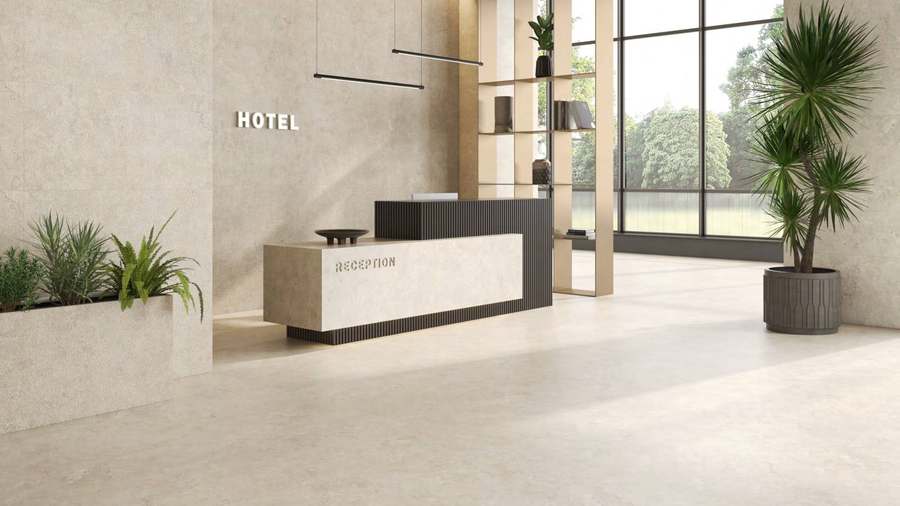Suelo de baldosa porcelánica de aspecto piedra clara en un salón amplio con luz natural