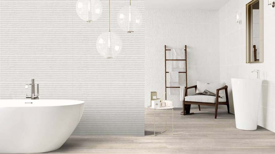 Baño con la pared revestida de baldosa blanca rectangular con textura y bañera exenta