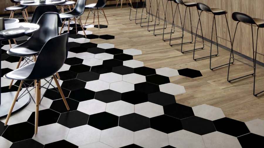Suelo de hexágonos blancos y negros que se funde con un suelo de madera en una cafetería