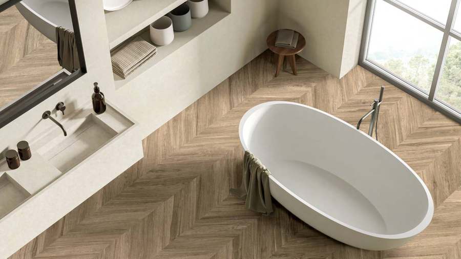Baño con bañera exenta y suelo de porcelánico imitación madera colocado en espiga