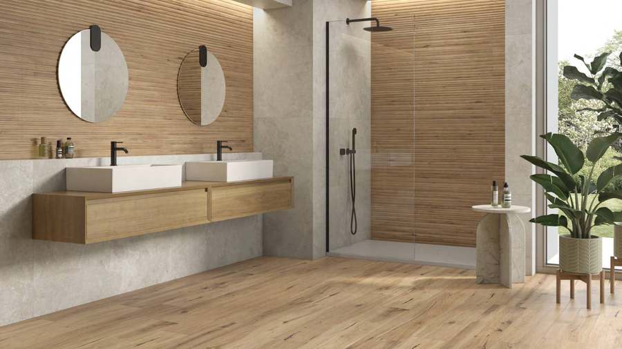Baño con suelo de lamas de aspecto madera clara y pared a juego, con dos lavabos sobre encimera de madera