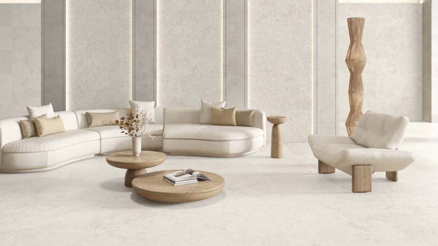 Salón amplio con suelo y paredes de porcelánico crema claro de aspecto piedra