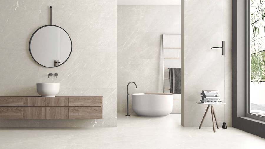 Baño amplio con bañera exenta, paredes y suelo de porcelánico claro de gran formato con muy pocas juntas