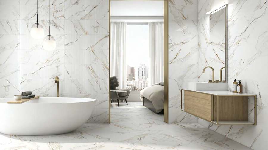 Baño con bañera exenta, paredes y suelo de porcelánico blanco con vetas grises y doradas