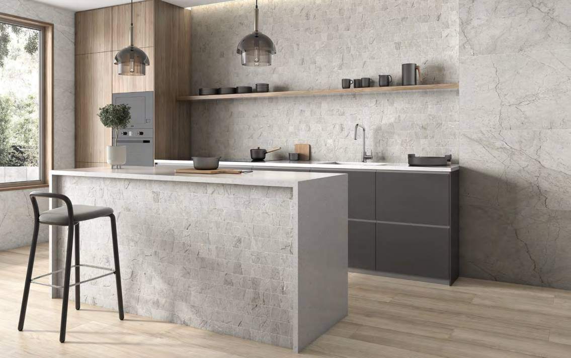 Cocina con mosaico de aspecto mármol gris en la pared de la encimera y en el frente de la isla