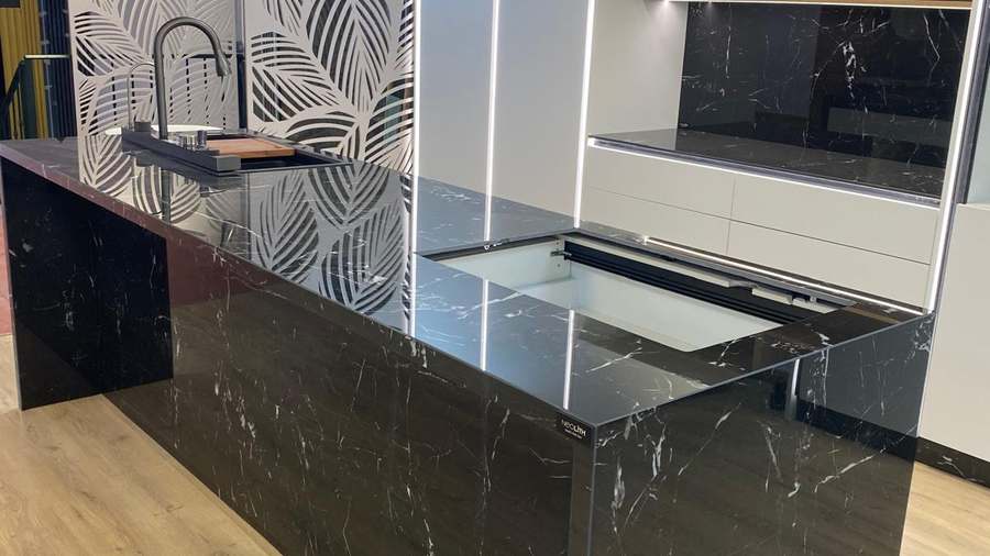 Isla de cocina con encimera negra de vetas blancas, acabado pulido y brillante